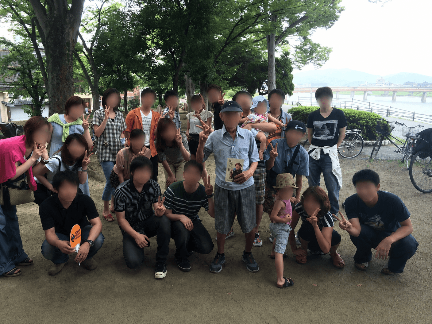 地域の人々が集まる野外イベントの活気ある風景。カラフルなテントと緑の公園